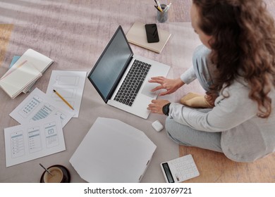 Young Female UX Designer Sitting On The Floor At Home And Working On Project