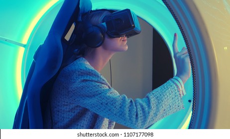 Young female in virtual reality headset selecting game for vr session - Powered by Shutterstock