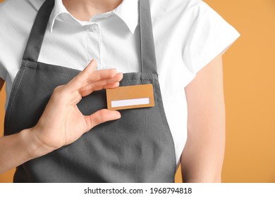 Young female waiter with blank badge on color background - Shutterstock ID 1968794818