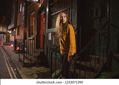 Young Female Walking Lost And Alone In A Dark Scary Street Alley. Cinematic Dark Alley.