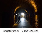 A young female walking in Western Wall Tunnel with yellow lghts