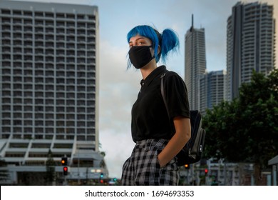 young female wearing medical mask in modern city street, stylish trendy girl with blue hair wearing fashionable protective medical mask amid coronavirus fears, covid19 pandemic, new fashion concept - Shutterstock ID 1694693353