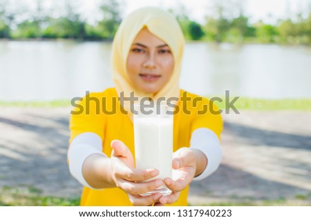 Young female women in hijab drink milk