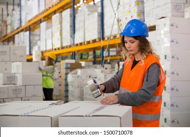 Young female worker packing boxes for shipment in warehouse - Powered by Shutterstock