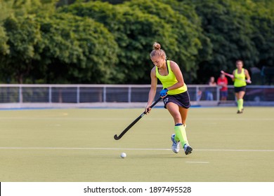 Young Field Hockey Female Player In Attack. Sporty Woman Player Leads The Ball