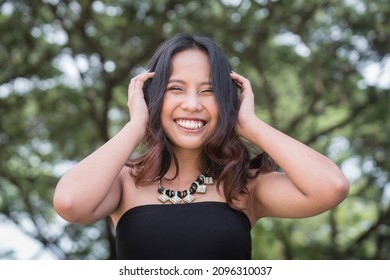 A young Filipina with a great personality. Having a great time outdoors. - Shutterstock ID 2096310037