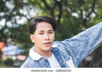 A Young Filipino Male In A Blue Denim Jacket And White Shirt. Outdoor Scene.