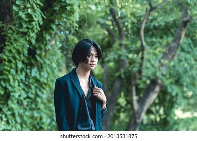 A Young Filipino Man In Deep Thought, Contemplating The Future Or Problematic. Blank Stare And Emotionless, Walking Outdoors At The Park.