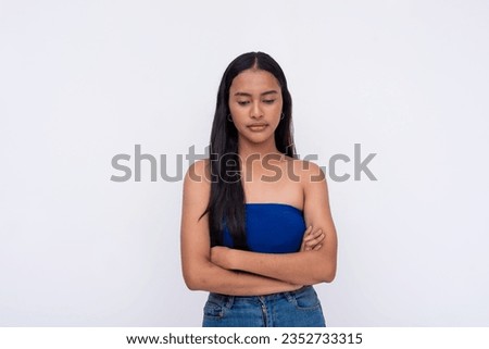 A young Filipino woman looking down, slightly disappointed. Expectations let down. Isolated on a white background.