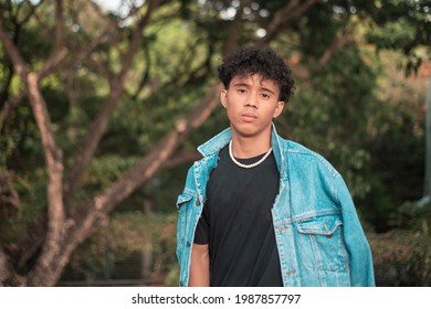 A young Filipino-African man. Handsome biracial young man outdoors. In a black shirt and denim jacket. - Powered by Shutterstock