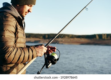 Young Fisherman Standing On The Shore Of Lake With Fishing Rod