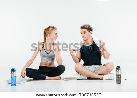 young fit couple relaxign after workingout isolated on white