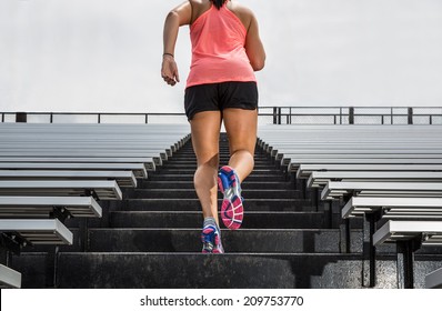 Young Fit Female Athlete Running Up Bleachers At A Stadium To Illustrate 