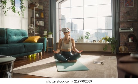 Young Fit Female Wearing Virtual Reality Headset, Practising Meditation in Modern Futuristic Way in Her Bright Sunny Loft Apartment. Healthy Lifestyle, Fitness, Wellbeing and Mindfulness. - Powered by Shutterstock