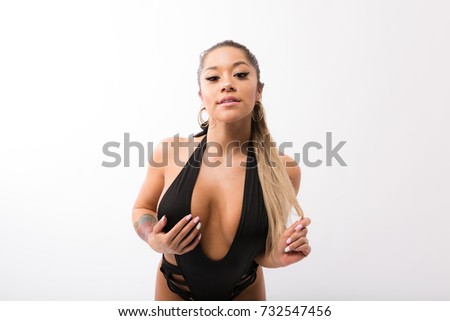 Young fit hispanic woman in black one piece and long striped socks on a white background