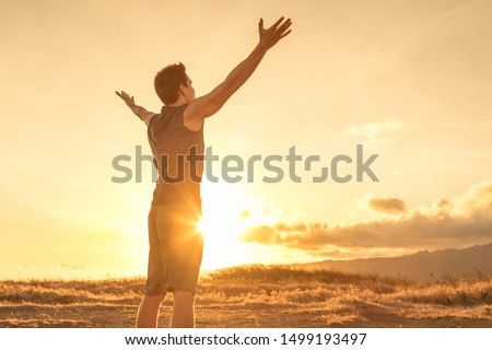 Young fit man felling hopeful, energized, and rejuvenated standing in a beautiful outdoor setting. Foto stock © 