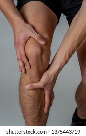 Young fit man holding knee with hands in pain after suffering muscle injury broken bone leg pain sprain or cramp during running workout. In Body pain and sport training injury and body health care. - Shutterstock ID 1375443719