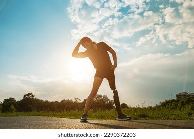 Young fit man with prosthetic leg doing stretching day routine outdoor - Focus on left leg - Powered by Shutterstock