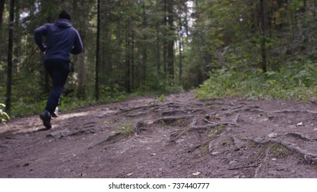 Young Fit Man Running In The Woods. Young Athlete Running In The Woods