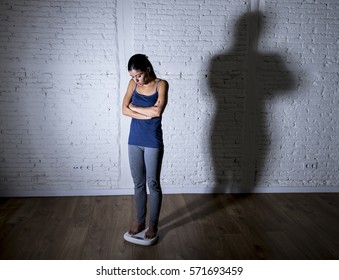 Young Fit Slim Woman Or Teen Girl Checking Body Weight On Scale With Big Shadow Light Sad Desperate And Frustrated Obsessed With Overweight In Anorexia And Bulimia Nutrition Disorder 