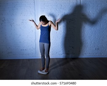 Young Fit Slim Woman Or Teen Girl Checking Body Weight On Scale With Big Shadow Light Sad Desperate And Frustrated Obsessed With Overweight In Anorexia And Bulimia Nutrition Disorder 