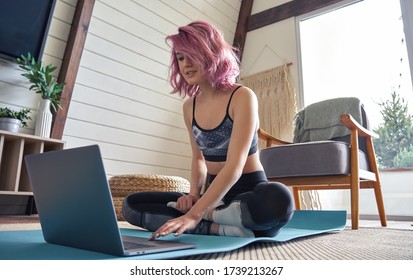 Young Fit Sporty Teen Hipster Girl Pink Hair Wear Sportswear Search Online Fitness Yoga Class Using Laptop Computer Sit At Home. Online Fitness Workout Video Tutorial Virtual Coach Teacher Concept.