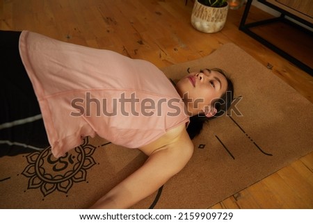Young fit woman bending on yoga mat practicing yoga in the room