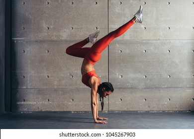 Young fit woman doing handstand exercise in studio. - Powered by Shutterstock