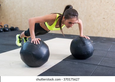 Young Fit Woman Doing Push Up On Medicine Ball At Gym.