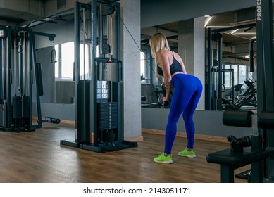 Young Fit Woman Doing Triceps Pull Down Rope Extension Exercise In Fitness Center. Girl Trains In The Gym