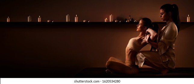 Young Fit Woman Has Thai Massage At Luxury Spa. Warm Inviting Colors, Calm Atmosphere, Charming Light. Copy Space