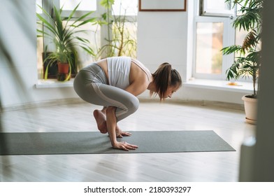 Young Fit Woman Practice Yoga Doing Asana In Light Yoga Studio With Green House Plants