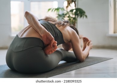 Young Fit Woman Practice Yoga Doing Asana In Light Yoga Studio With Green House Plants