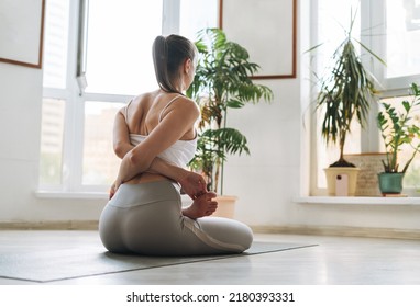 Young Fit Woman Practice Yoga Doing Asana In Light Yoga Studio With Green House Plants