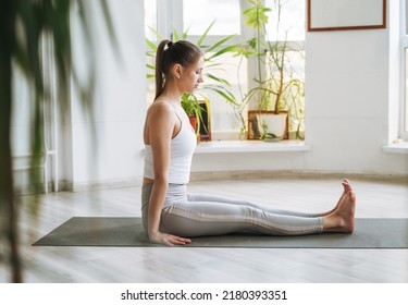 Young Fit Woman Practice Yoga Doing Asana In Light Yoga Studio With Green House Plants