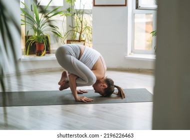 Young Fit Woman Practice Yoga Doing Asana In Light Yoga Studio With Green House Plants