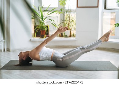 Young Fit Woman Practice Yoga Doing Asana In Light Yoga Studio With Green House Plants