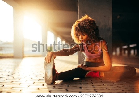 Similar – Young black woman doing stretching after running outdoors