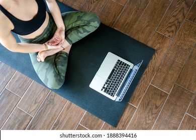 Young fit woman taking a meditation yoga class online in her home on yoga mat - Shutterstock ID 1888394416