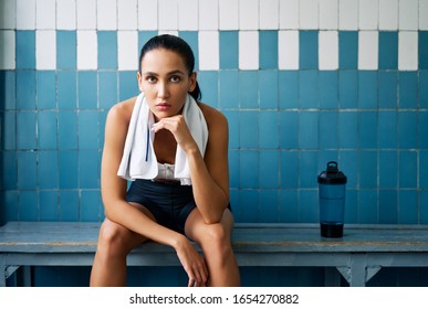 Young fit woman with a towel in the locker room relax after hard workout. Sport concept - Powered by Shutterstock