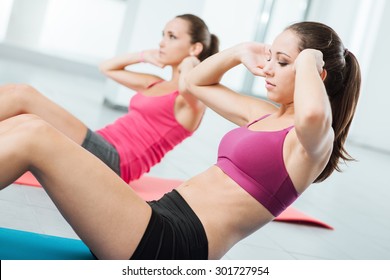 Young Fit Women At The Gym Doing Abs Workout On A Mat, Healthy Lifestyle And Fitness Concept