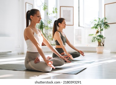 Young Fit Women Practice Yoga Doing Lotus Asana In Bright Yoga Studio