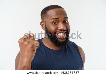 Similar – Cheerful man celebrating his success with a broad smile and raised fist in front of a neutral background