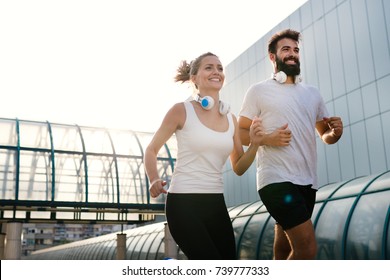 Young Fitness Couple Running In Urban Area