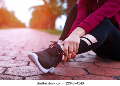 A young, fitness girl in sneakers and sportswear was injured while jogging and sports training. Leg injury and muscle strain, and ankle sprain accident during sports exercise. Sport legs 