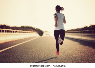 Young fitness sport woman running on city road - Shutterstock ID 732909076