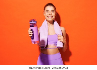 Young fitness trainer instructor sporty woman sportsman wear purple top clothes spend time in home gym hold towel give bottle of water isolated on plain orange background Workout sport fit abs concept - Powered by Shutterstock