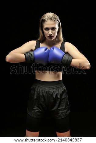 Similar – Close up front upper body portrait of one young athletic woman in sportswear in gym over dark background, looking at camera