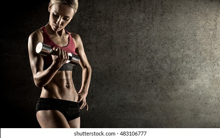 young fitness woman , execute exercise with dumbbells, on concrete slab background - Shutterstock ID 483106777
