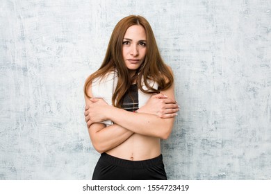 Young fitness woman going cold due to low temperature or a sickness. - Powered by Shutterstock